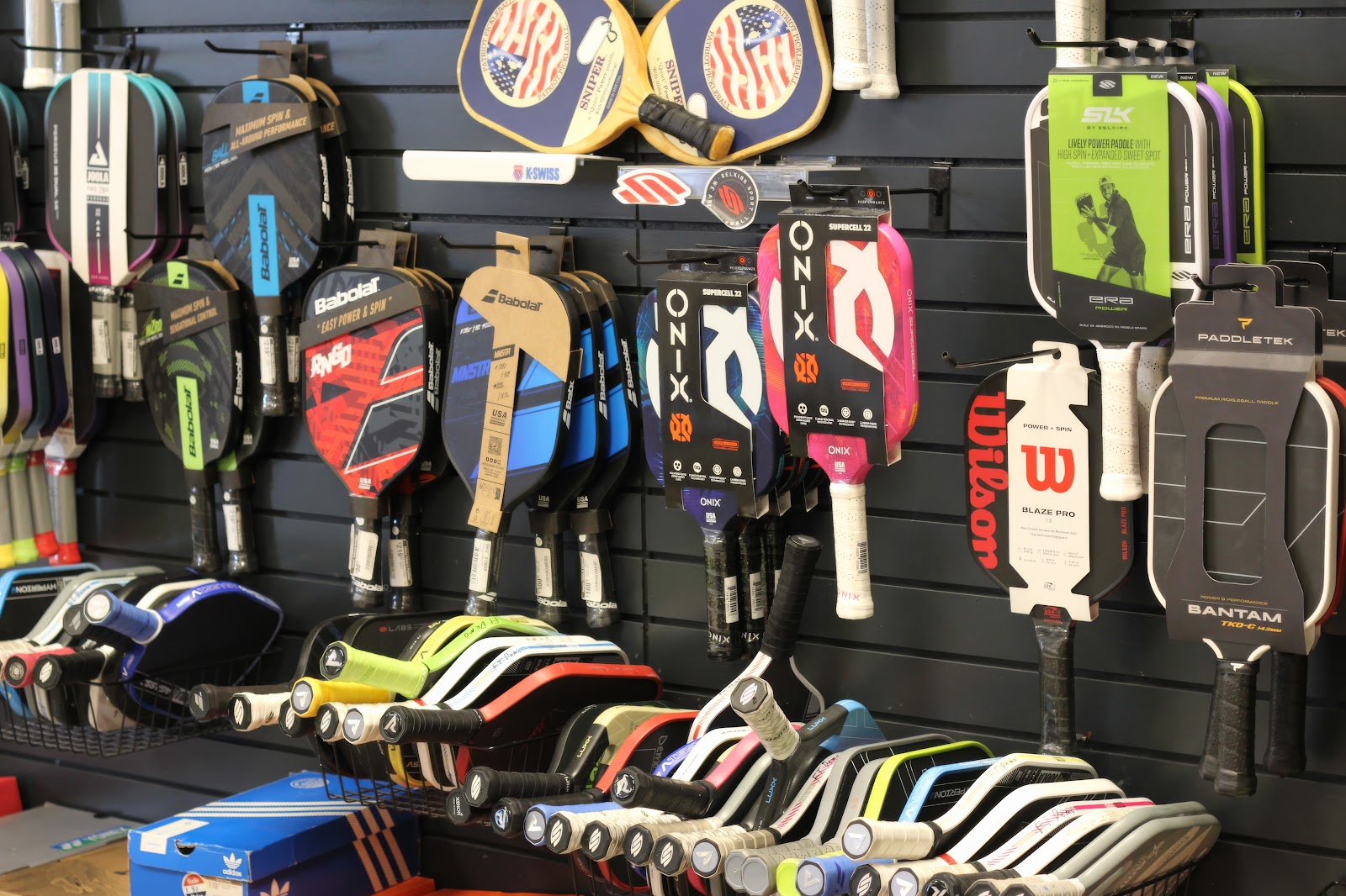 Padel paddles on the wall at Forever Tennis.