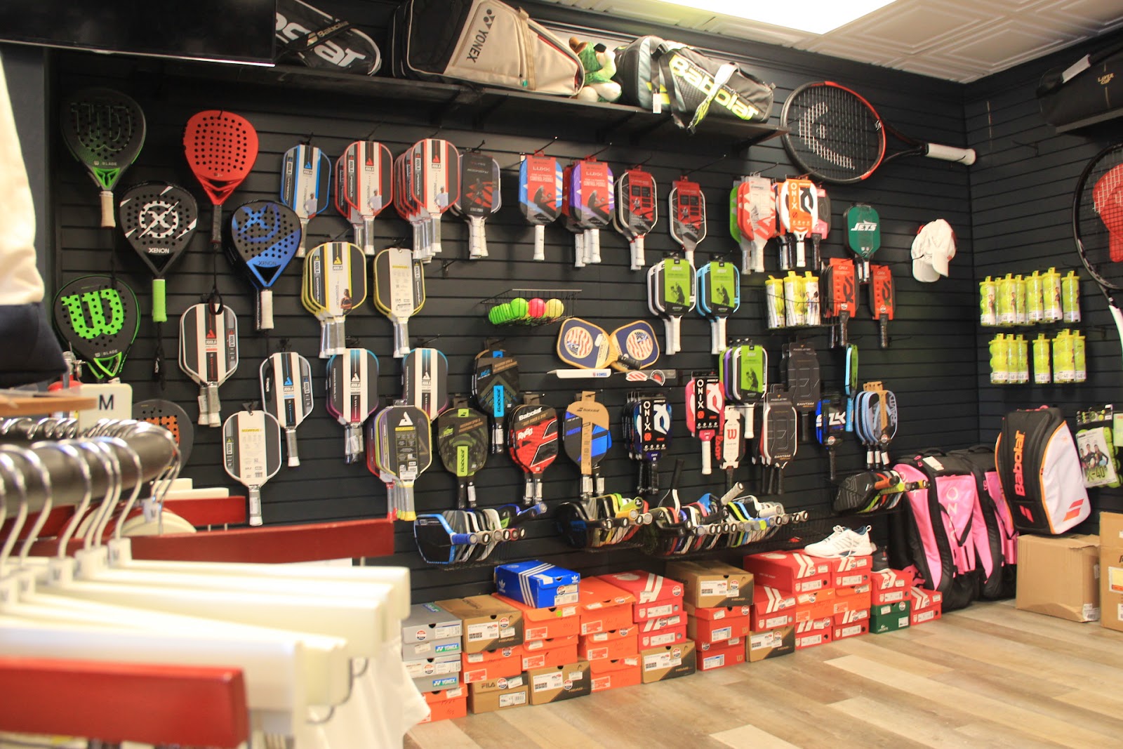 The pickleball paddle wall at Forever Tennis featuring Selkirk, Joola, Paddletek, Onix and more.