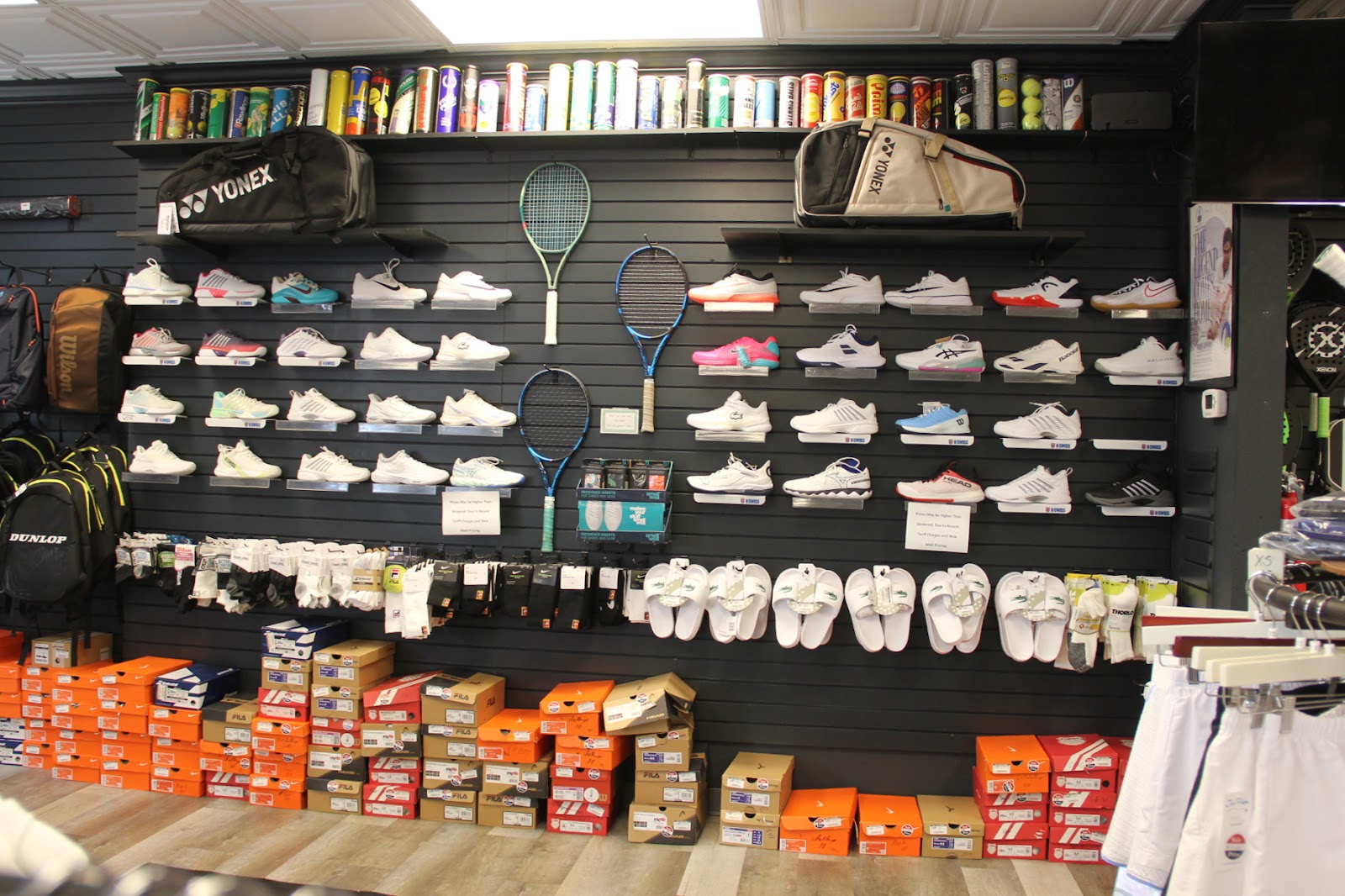 Wall of tennis and pickleball court shoes at Forever Tennis.