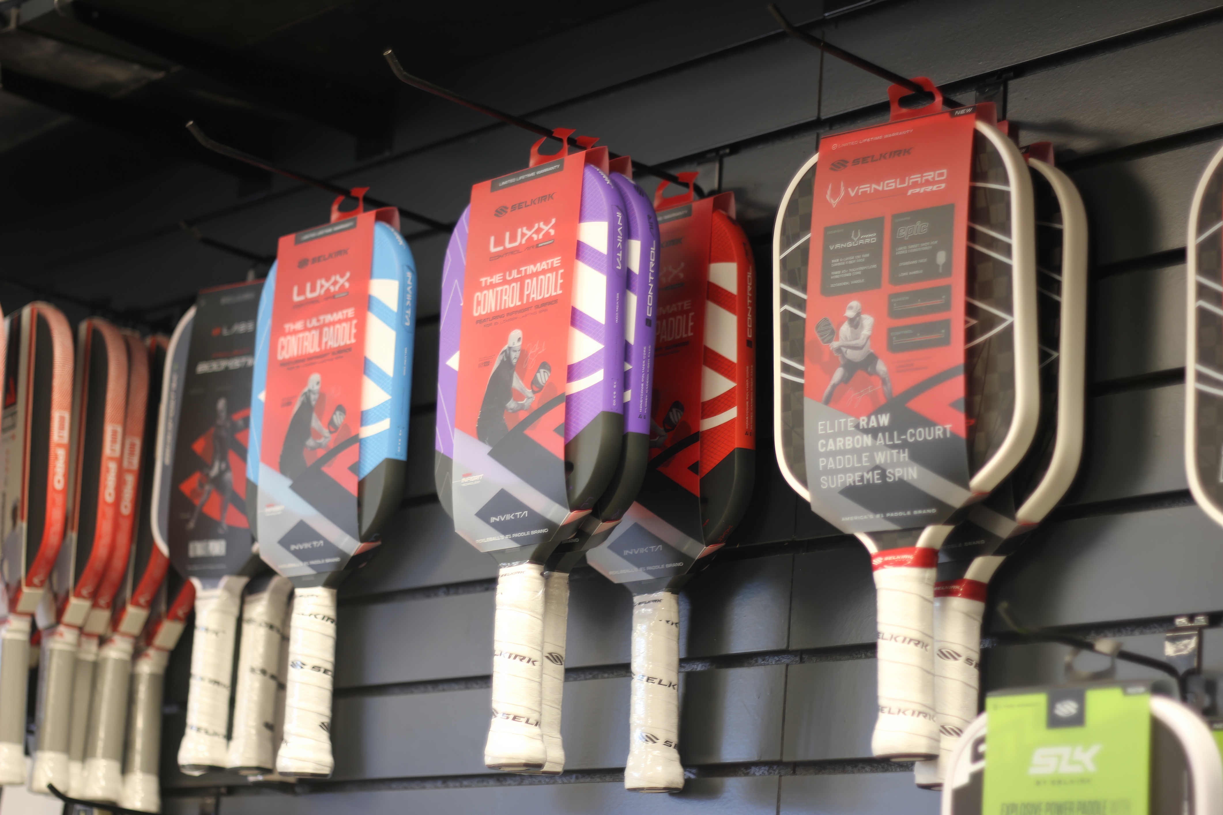 Tennis and pickleball racquets and paddles on display